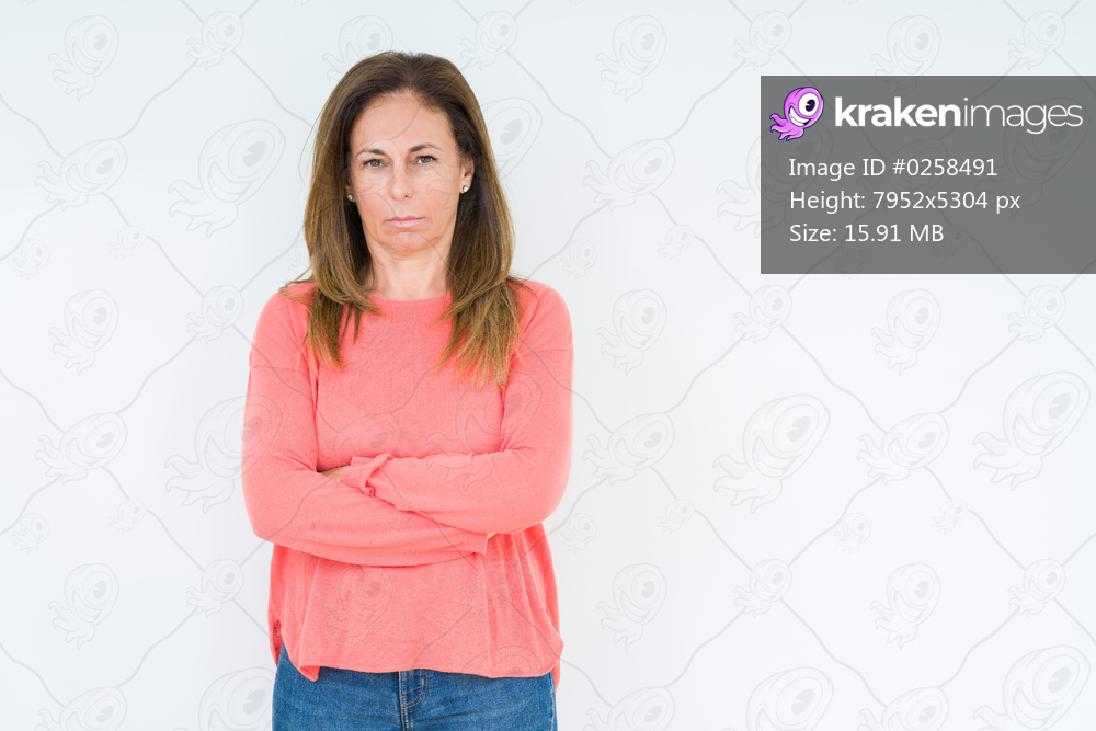 Beautiful middle age woman over isolated background skeptic and nervous, disapproving expression on face with crossed arms. Negative person.