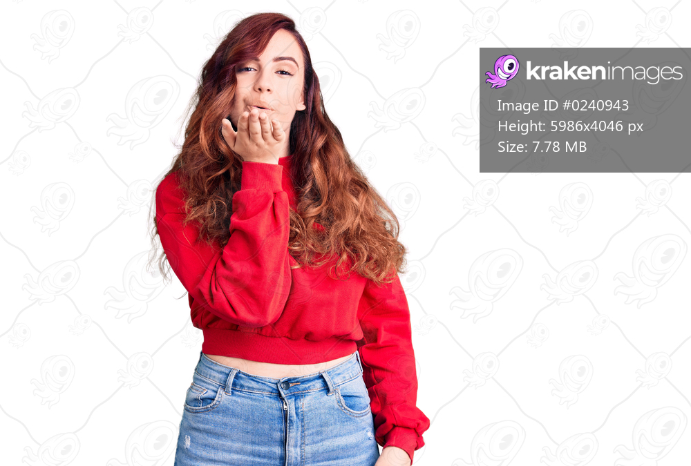 Young beautiful woman wearing casual winter sweater looking at the camera blowing a kiss with hand on air being lovely and sexy. love expression. 