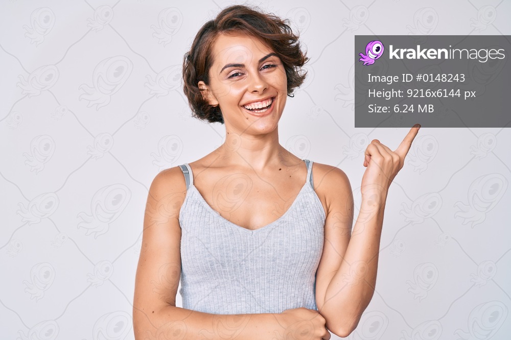 Young hispanic woman wearing casual clothes smiling happy pointing with hand and finger to the side 