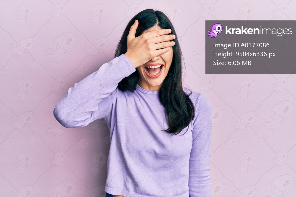 Young hispanic woman wearing casual clothes smiling and laughing with hand on face covering eyes for surprise. blind concept. 