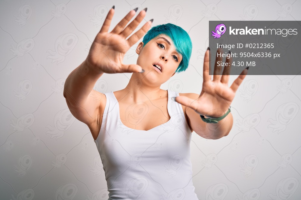 Young beautiful woman with blue fashion hair wearing casual t-shirt over white background doing frame using hands palms and fingers, camera perspective