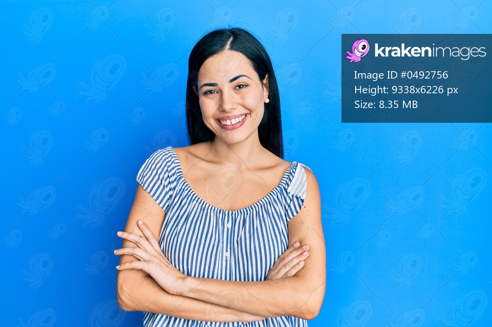 Beautiful young woman wearing casual clothes happy face smiling with crossed arms looking at the camera. positive person. 
