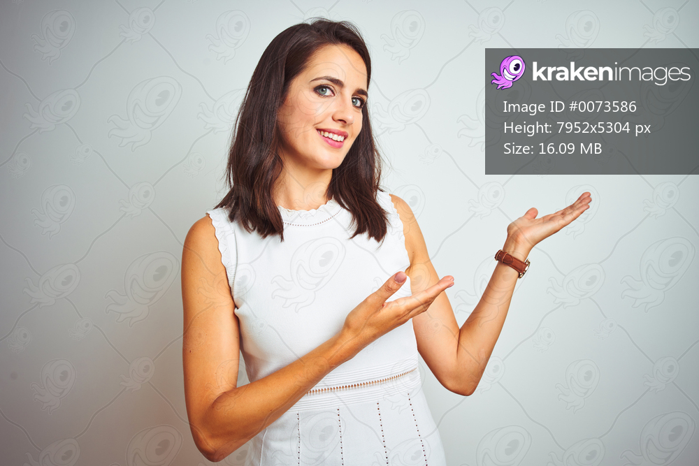 Young beautiful woman wearing dress standing over white isolated background Inviting to enter smiling natural with open hand