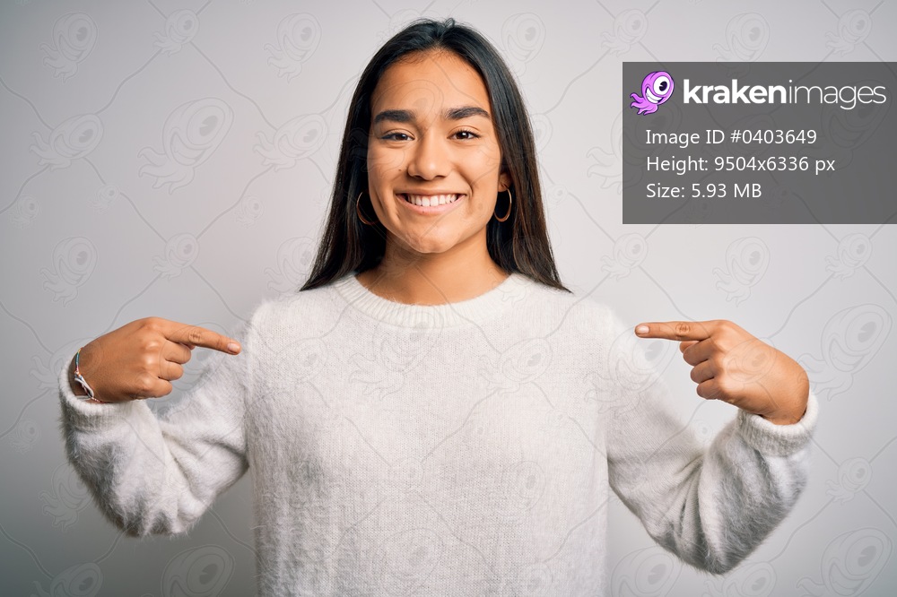 Young beautiful asian woman wearing casual sweater standing over white background looking confident with smile on face, pointing oneself with fingers proud and happy.