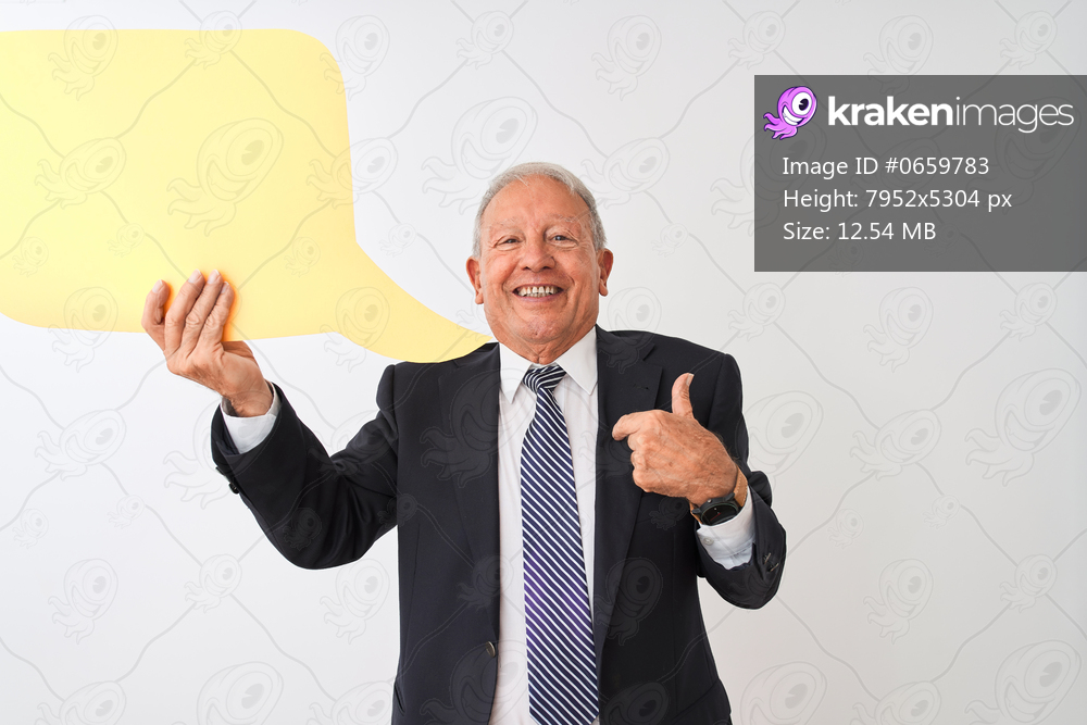 Senior grey-haired businessman holding speech bubble over isolated white background with surprise face pointing finger to himself