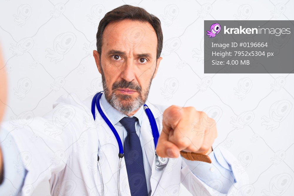 Middle age doctor man wearing stethoscope make selfie over isolated white background pointing with finger to the camera and to you, hand sign, positive and confident gesture from the front