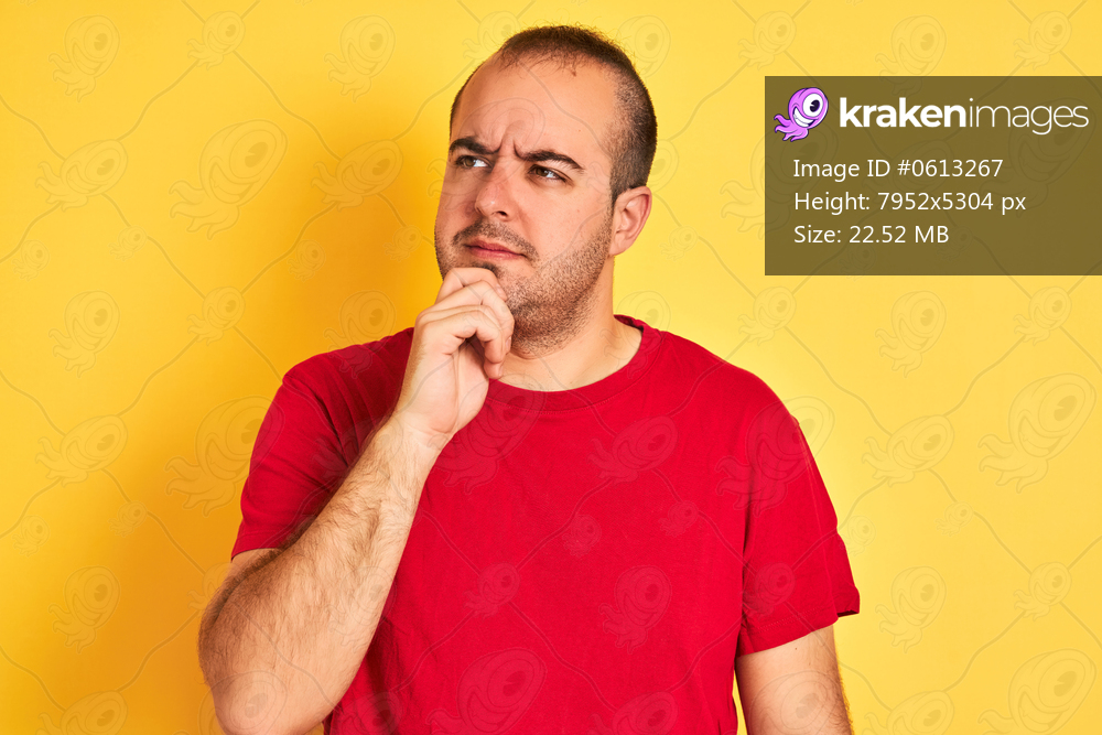 Young man wearing red casual t-shirt standing over isolated yellow background serious face thinking about question, very confused idea