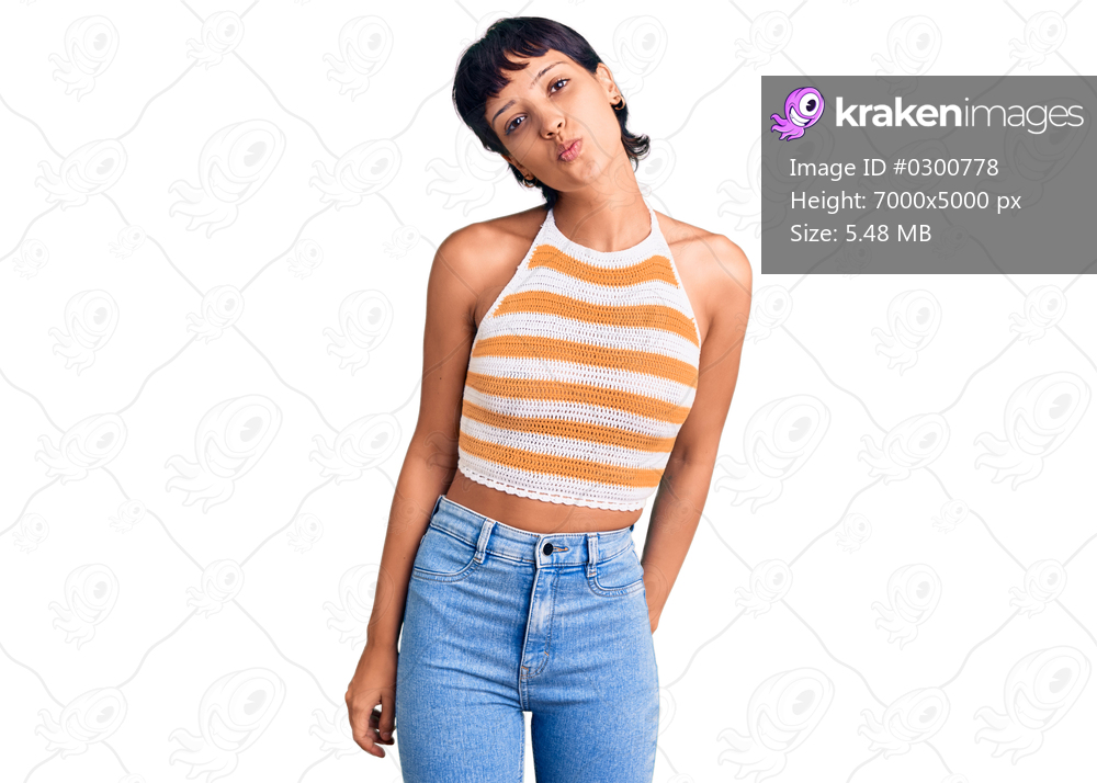 Young brunette woman with short hair wearing casual clothes looking at the camera blowing a kiss on air being lovely and sexy. love expression. 