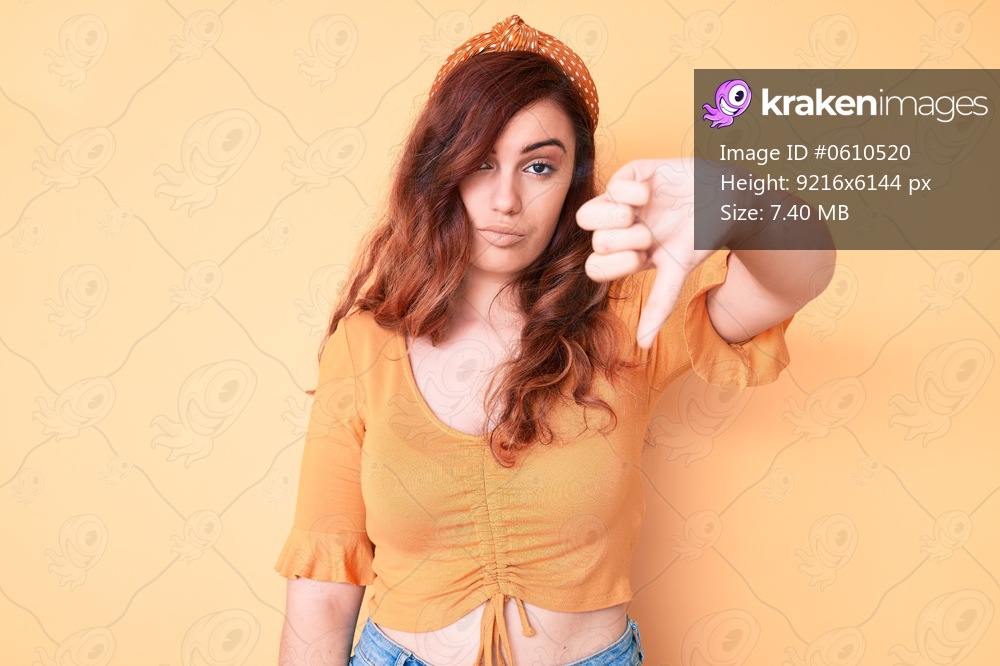 Young beautiful woman wearing casual clothes looking unhappy and angry showing rejection and negative with thumbs down gesture. bad expression. 