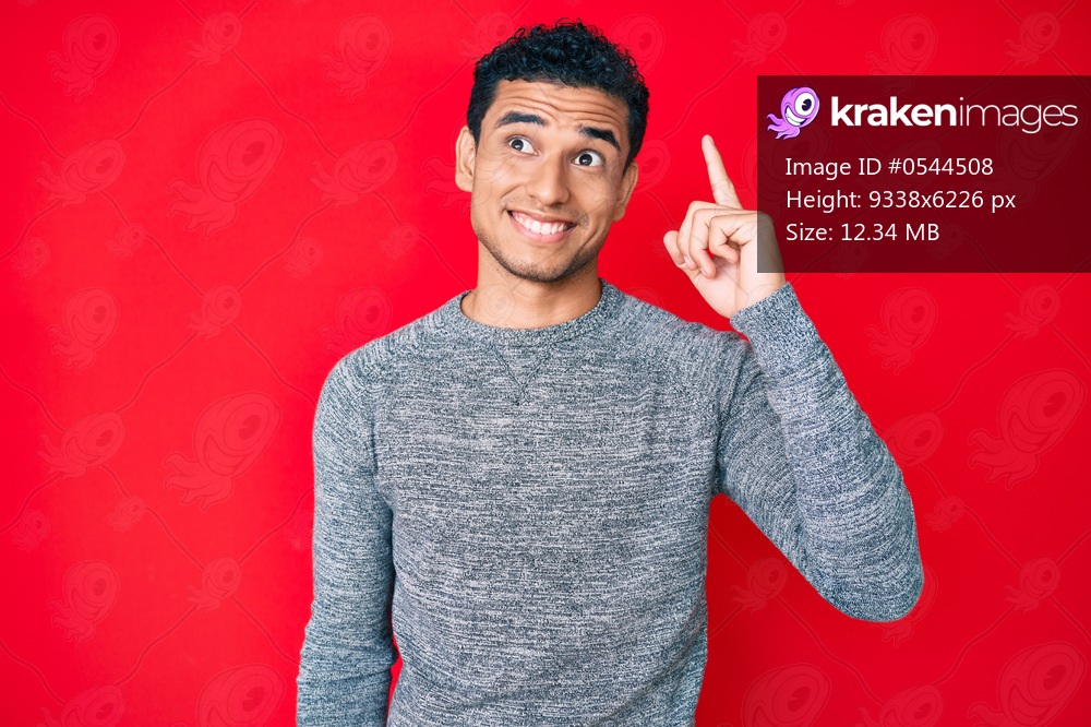 Young handsome hispanic man over red background pointing finger up with successful idea. exited and happy. number one. 