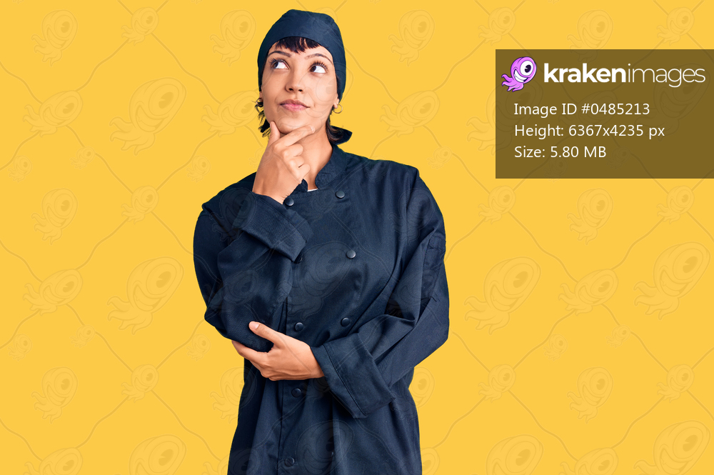 Young brunette woman with short hair wearing professional cook uniform with hand on chin thinking about question, pensive expression. smiling with thoughtful face. doubt concept. 