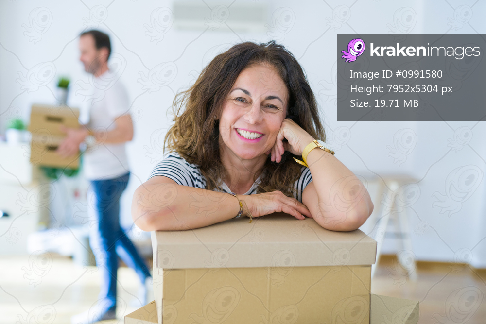 Middle age senior couple moving to a new house, woman smiling happy in love with new apartment