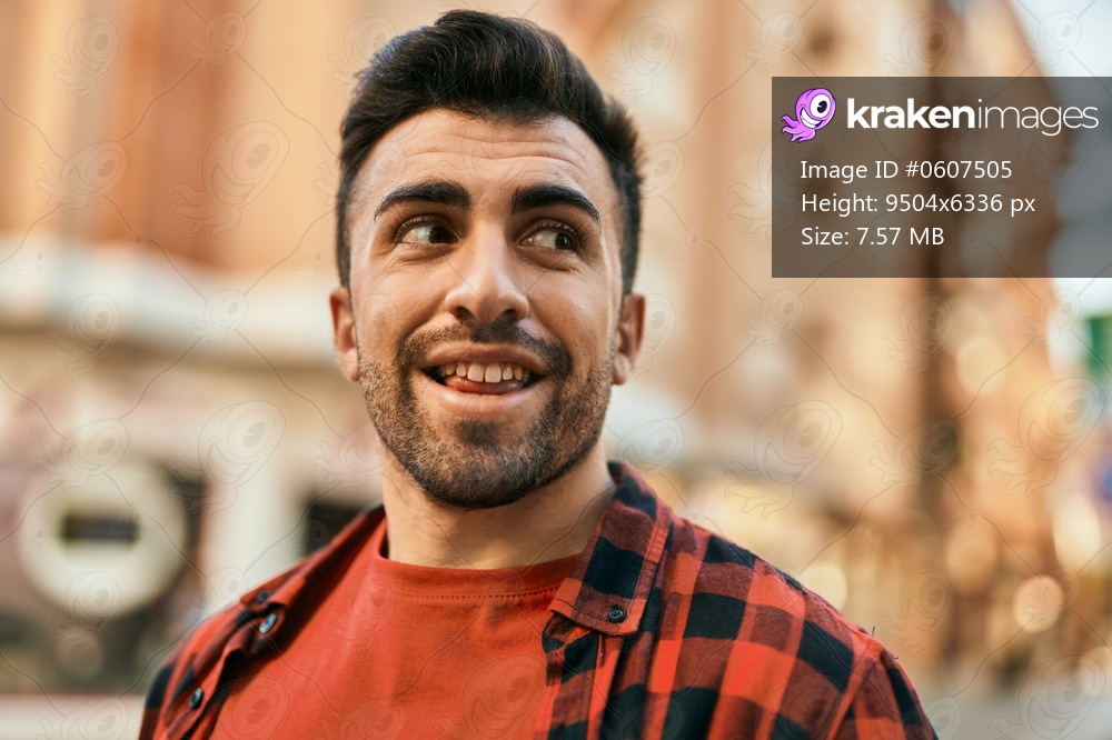 Young hispanic man smiling happy standing at the city.