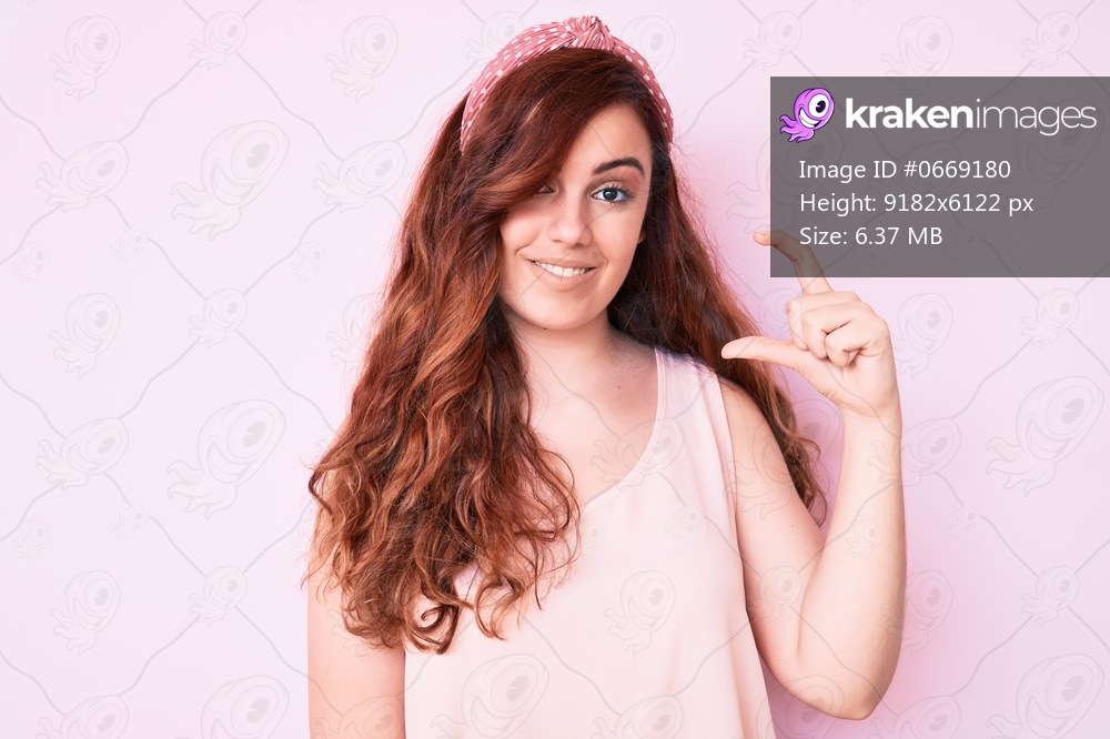 Young beautiful woman wearing casual clothes smiling and confident gesturing with hand doing small size sign with fingers looking and the camera. measure concept. 