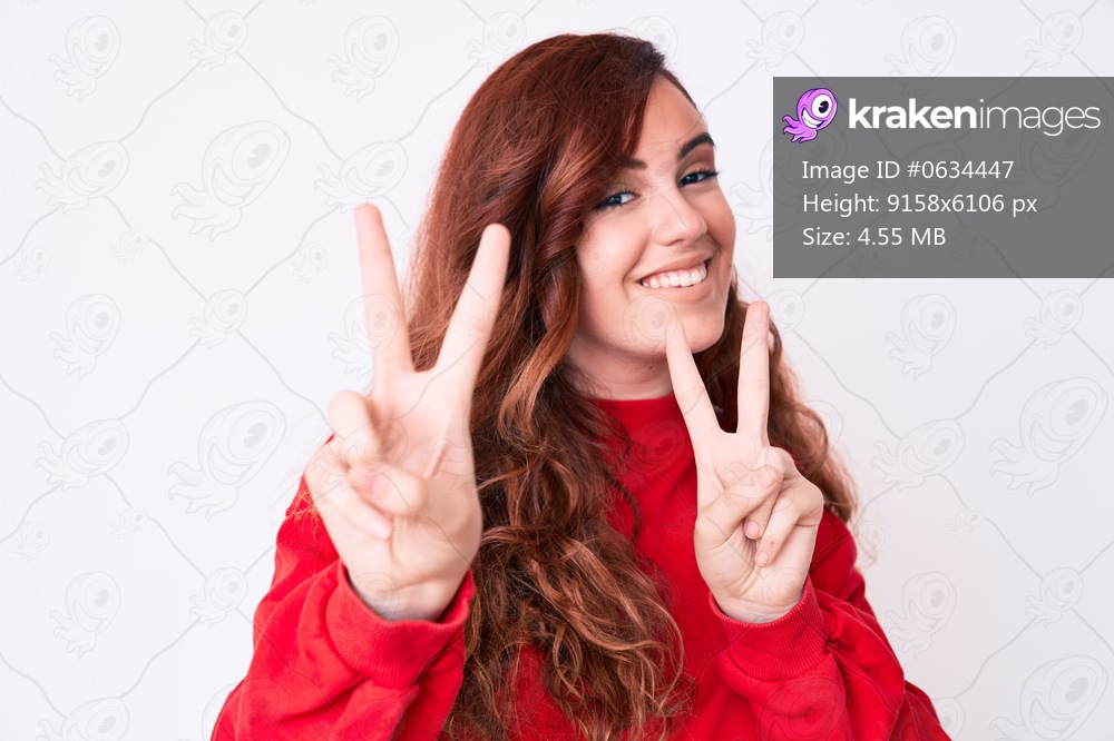 Young beautiful woman wearing casual clothes smiling looking to the camera showing fingers doing victory sign. number two. 