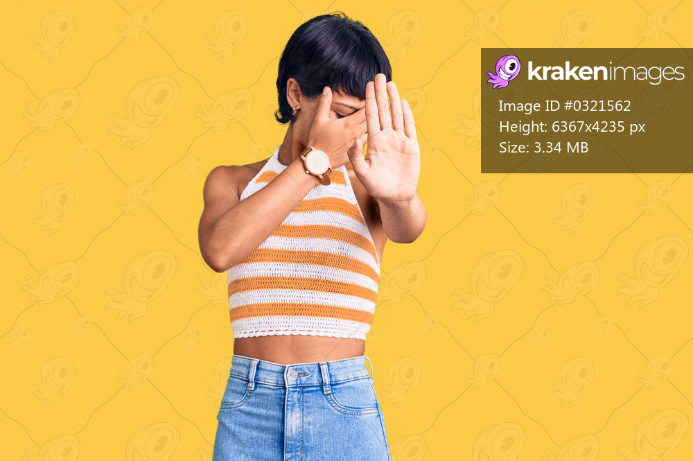 Young brunette woman with short hair wearing casual clothes covering eyes with hands and doing stop gesture with sad and fear expression. embarrassed and negative concept. 
