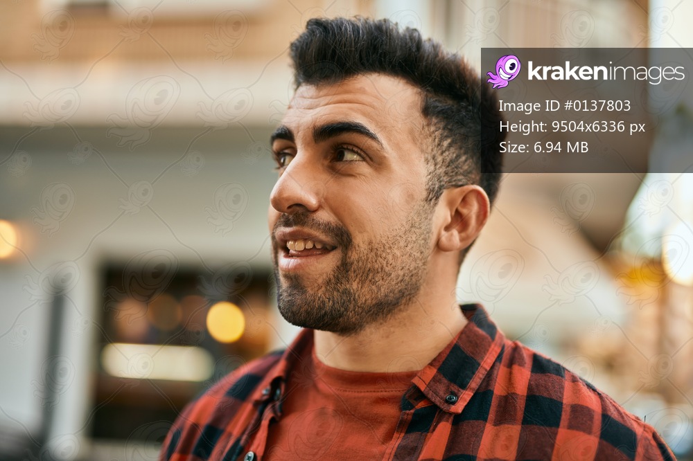 Young hispanic man smiling happy standing at the city.