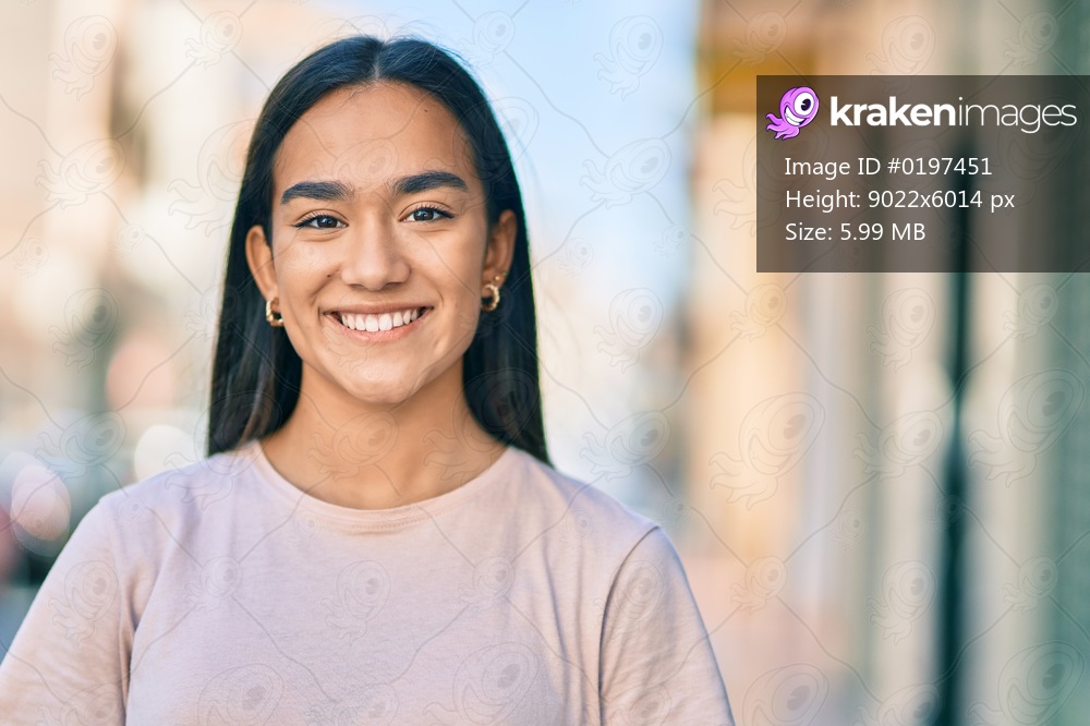 Young latin girl smiling happy standing at the city.