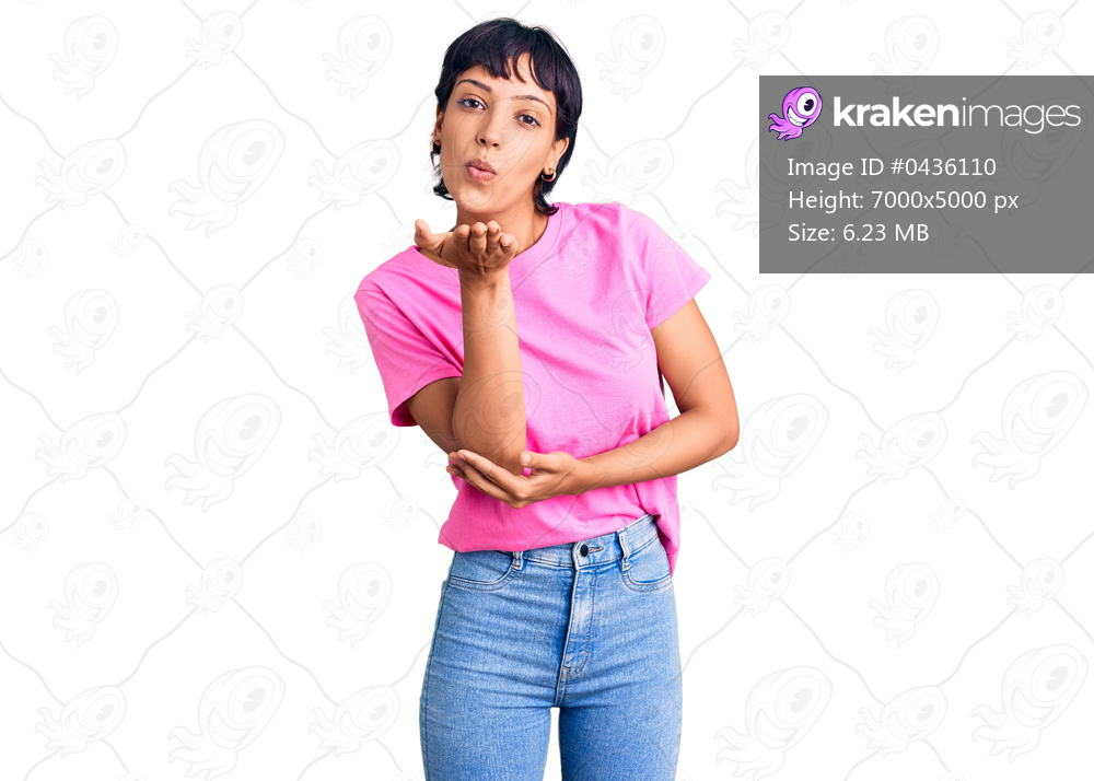 Young brunette woman with short hair wearing casual clothes looking at the camera blowing a kiss with hand on air being lovely and sexy. love expression. 