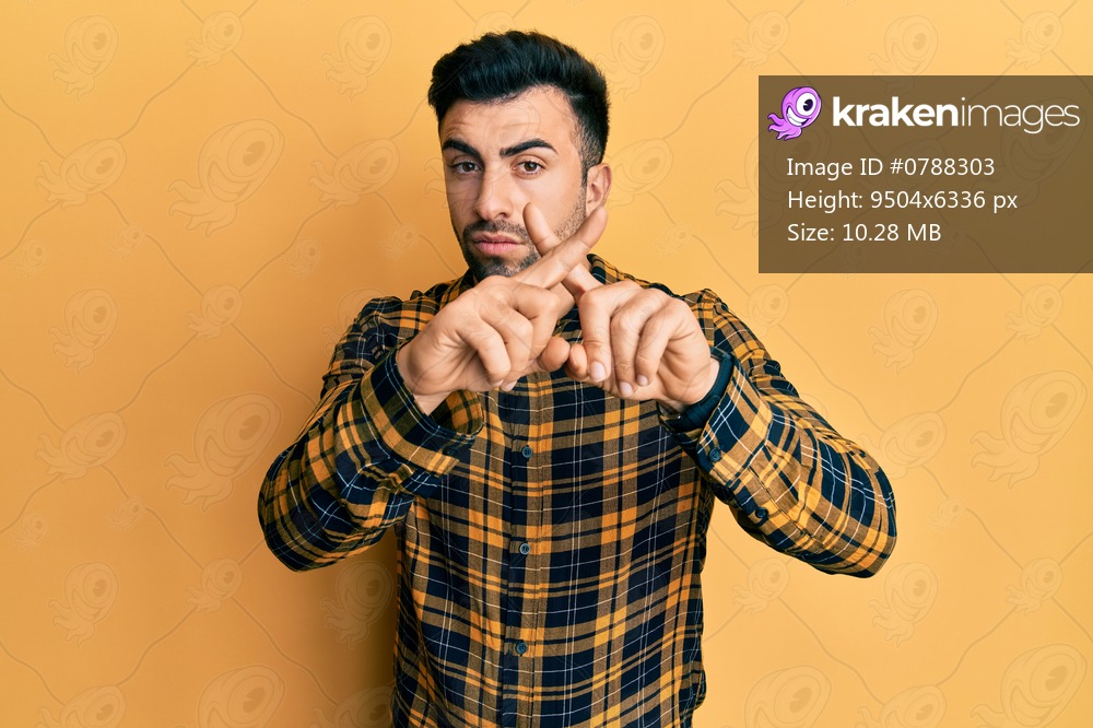 Young hispanic man wearing casual clothes rejection expression crossing fingers doing negative sign 