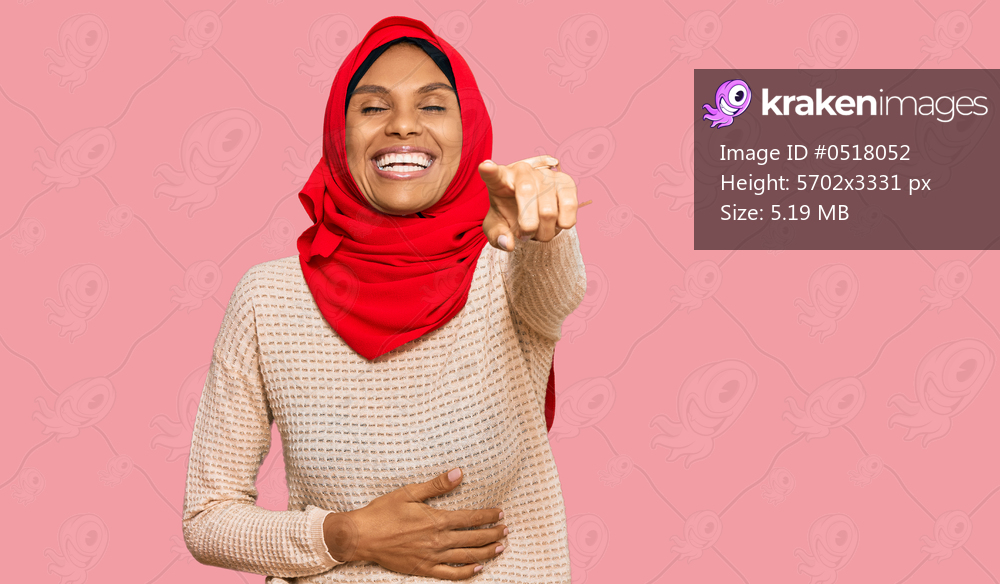Young african american woman wearing traditional islamic hijab scarf laughing at you, pointing finger to the camera with hand over body, shame expression 