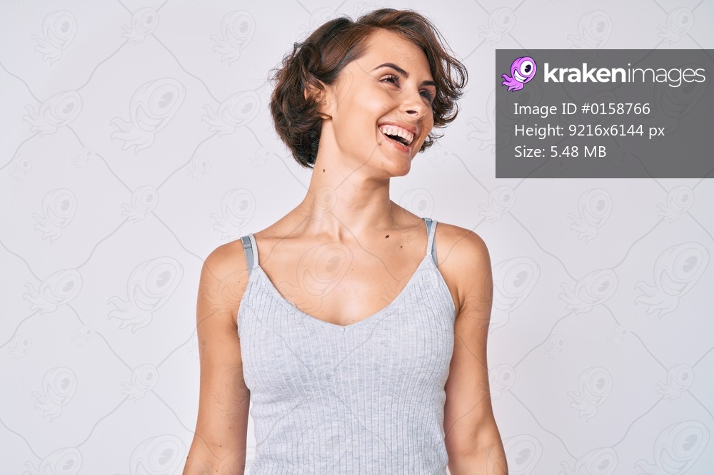Young hispanic woman wearing casual clothes looking away to side with smile on face, natural expression. laughing confident. 