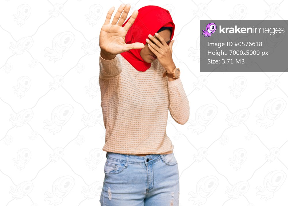 Young african american woman wearing traditional islamic hijab scarf covering eyes with hands and doing stop gesture with sad and fear expression. embarrassed and negative concept. 