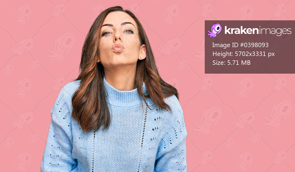 Young brunette woman wearing casual winter sweater looking at the camera blowing a kiss on air being lovely and sexy. love expression. 