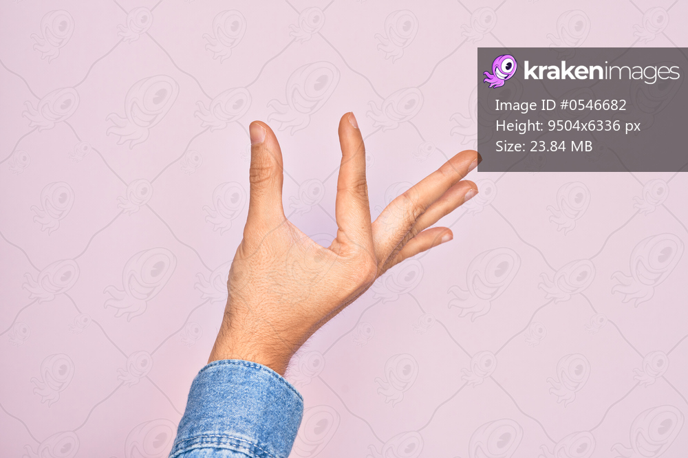 Hand of caucasian young man showing fingers over isolated pink background picking and taking invisible thing, holding object with fingers showing space
