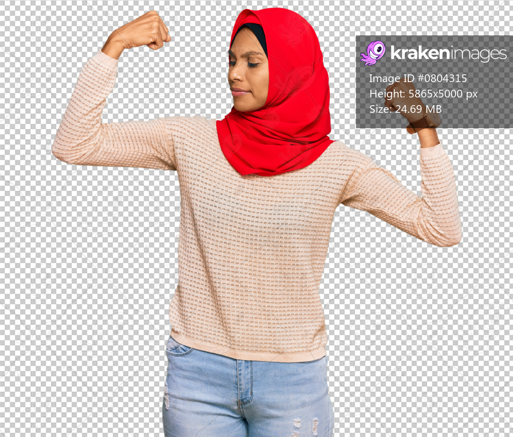 Young african american woman wearing traditional islamic hijab scarf showing arms muscles smiling proud. fitness concept.