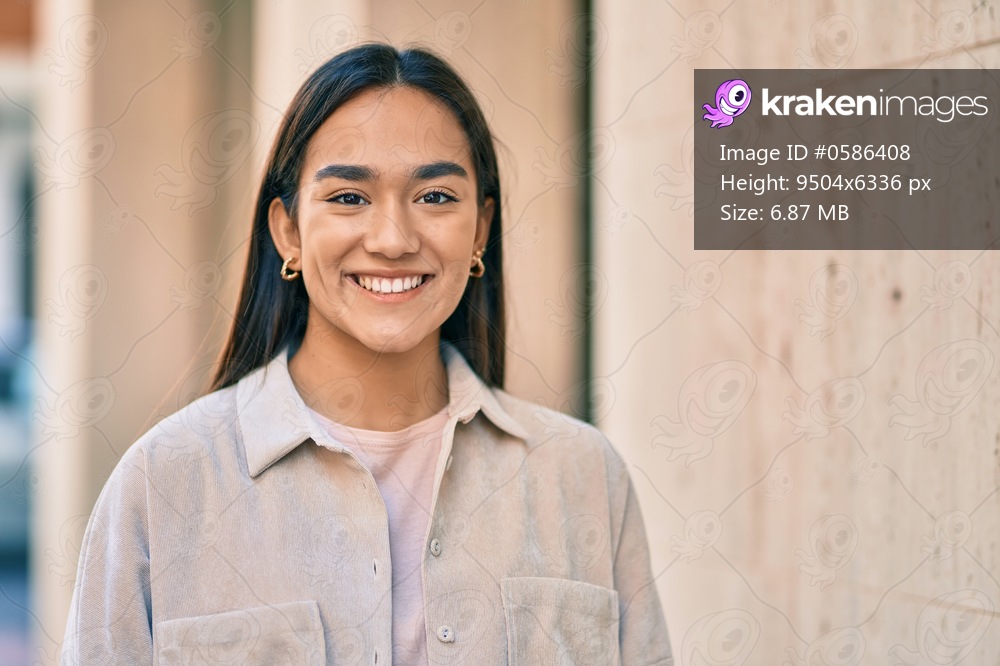 Young latin girl smiling happy standing at the city.