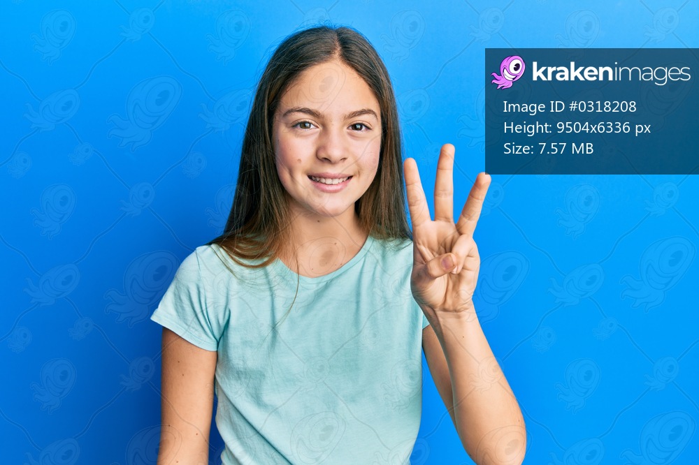 Beautiful brunette little girl wearing casual white t shirt showing and pointing up with fingers number three while smiling confident and happy. 