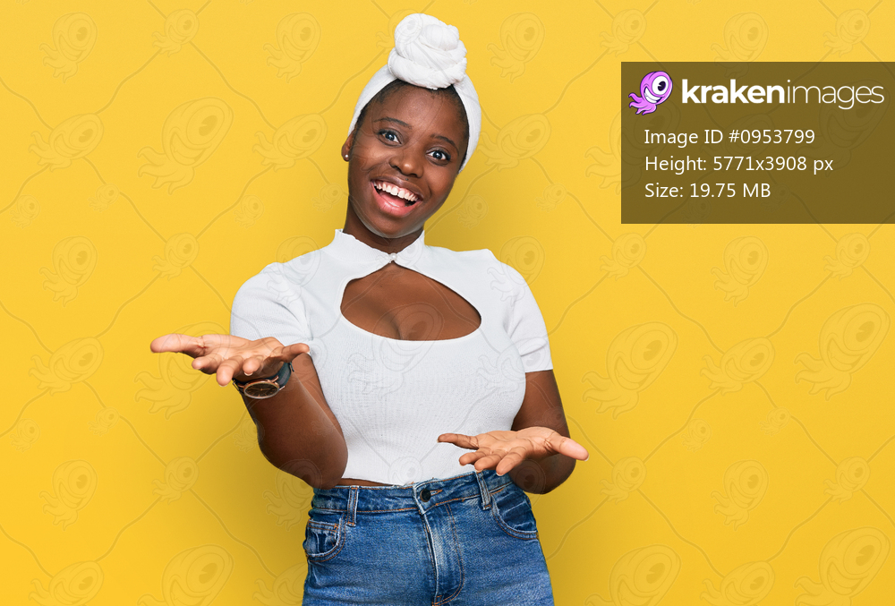 Young african woman with turban wearing hair turban over isolated background smiling cheerful with open arms as friendly welcome, positive and confident greetings 