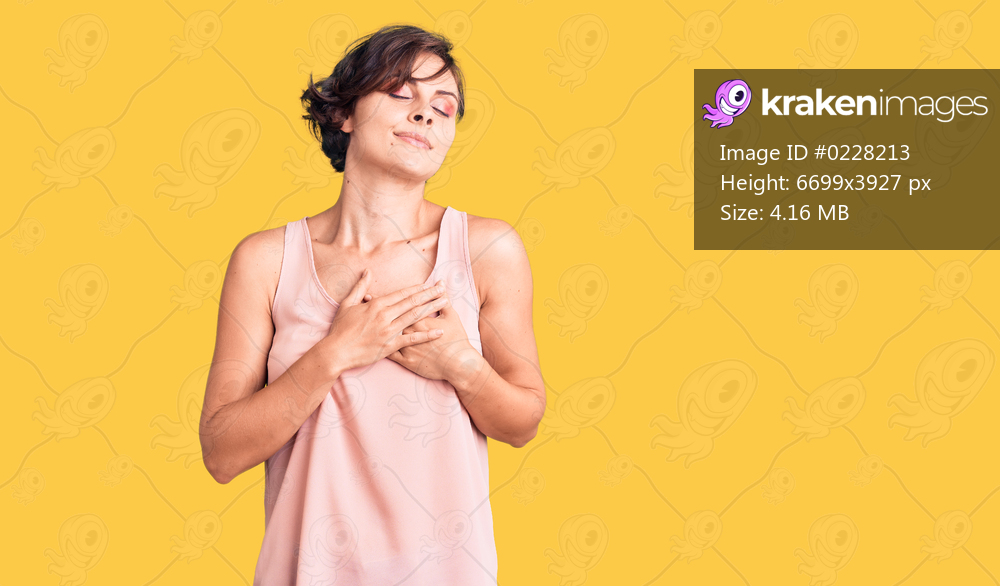 Beautiful young woman with short hair wearing casual style with sleeveless shirt smiling with hands on chest with closed eyes and grateful gesture on face. health concept. 