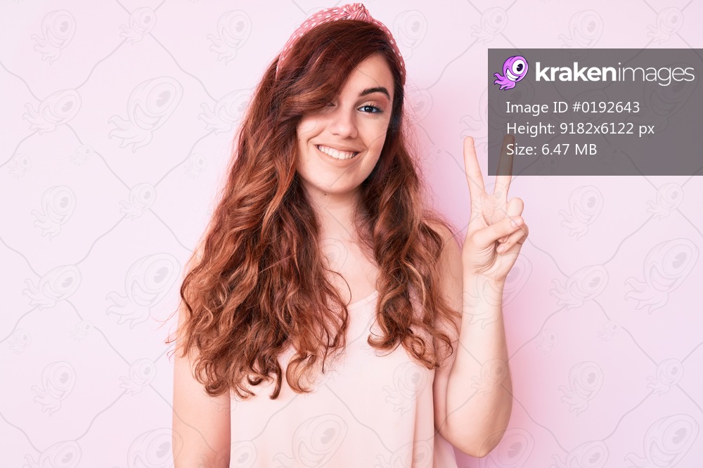 Young beautiful woman wearing casual clothes smiling looking to the camera showing fingers doing victory sign. number two. 