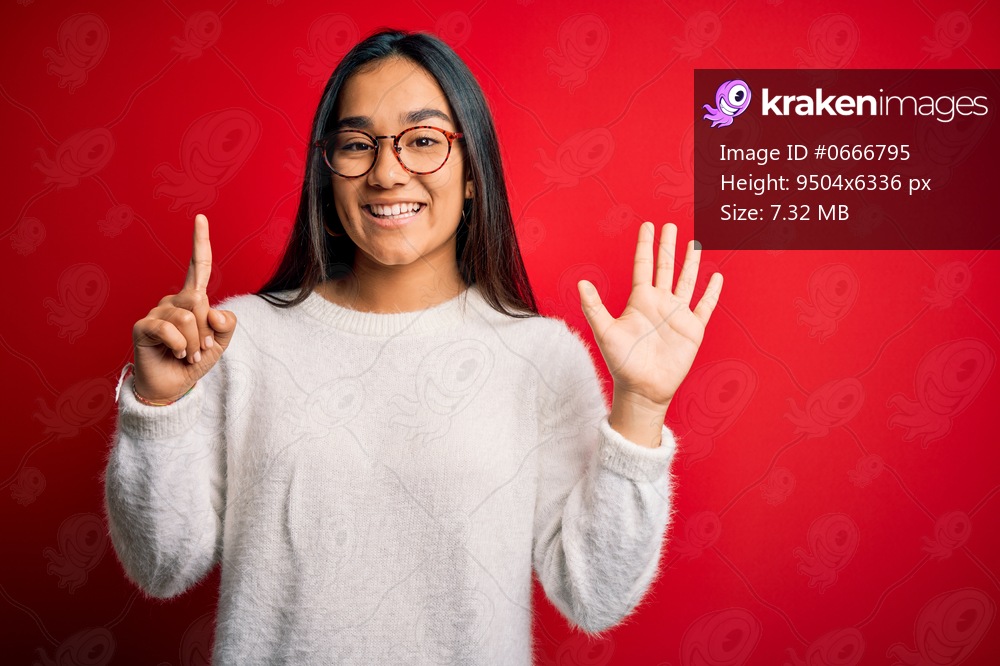 Young beautiful asian woman wearing casual sweater and glasses over red background showing and pointing up with fingers number six while smiling confident and happy.
