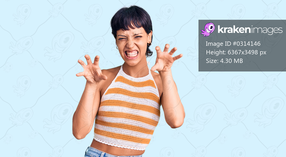 Young brunette woman with short hair wearing casual clothes smiling funny doing claw gesture as cat, aggressive and sexy expression 