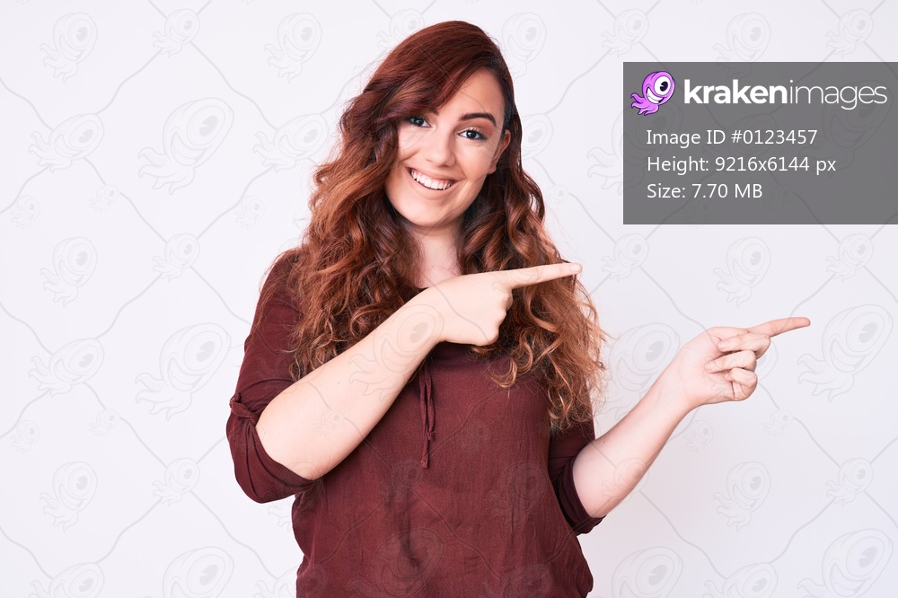 Young beautiful woman wearing casual clothes smiling and looking at the camera pointing with two hands and fingers to the side. 