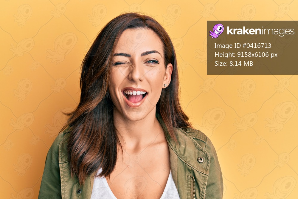 Young brunette woman wearing casual clothes over yellow background winking looking at the camera with sexy expression, cheerful and happy face. 
