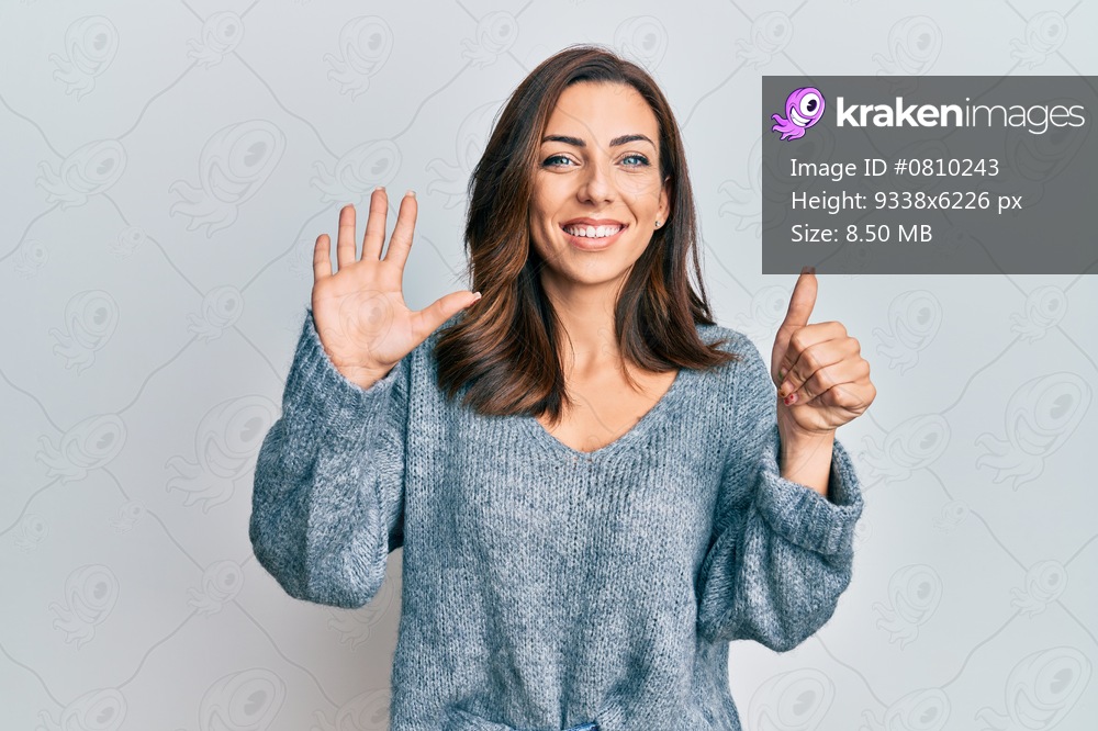 Young brunette woman wearing casual winter sweater showing and pointing up with fingers number six while smiling confident and happy. 