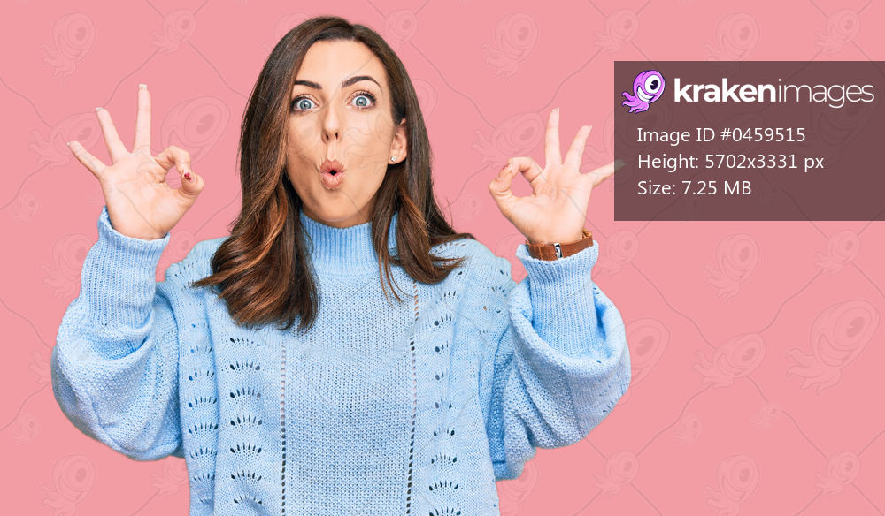 Young brunette woman wearing casual winter sweater looking surprised and shocked doing ok approval symbol with fingers. crazy expression 