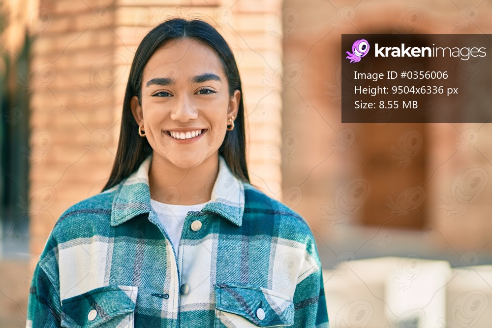 Young latin girl smiling happy standing at the city.
