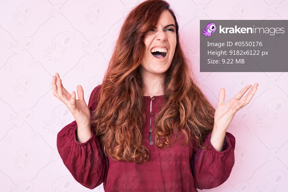 Young beautiful woman wearing casual winter sweater crazy and mad shouting and yelling with aggressive expression and arms raised. frustration concept. 