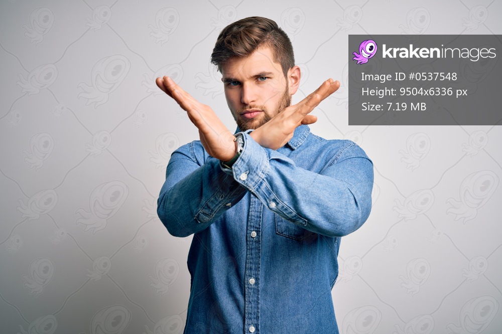 Young handsome blond man with beard and blue eyes wearing casual denim shirt Rejection expression crossing arms and palms doing negative sign, angry face