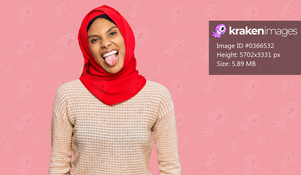 Young african american woman wearing traditional islamic hijab scarf sticking tongue out happy with funny expression. emotion concept. 