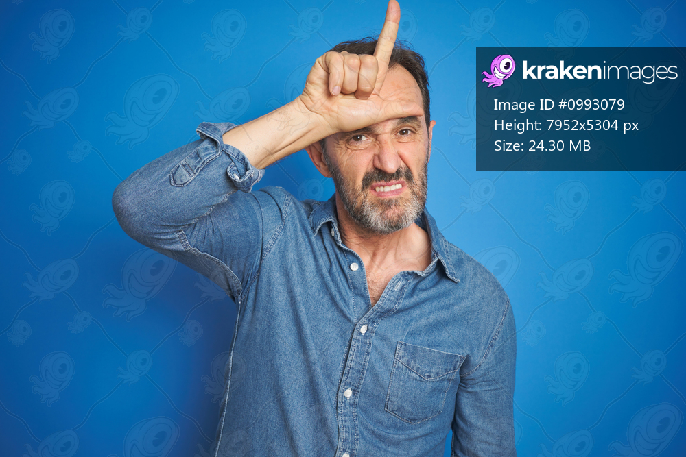 Handsome middle age senior man with grey hair over isolated blue background making fun of people with fingers on forehead doing loser gesture mocking and insulting.