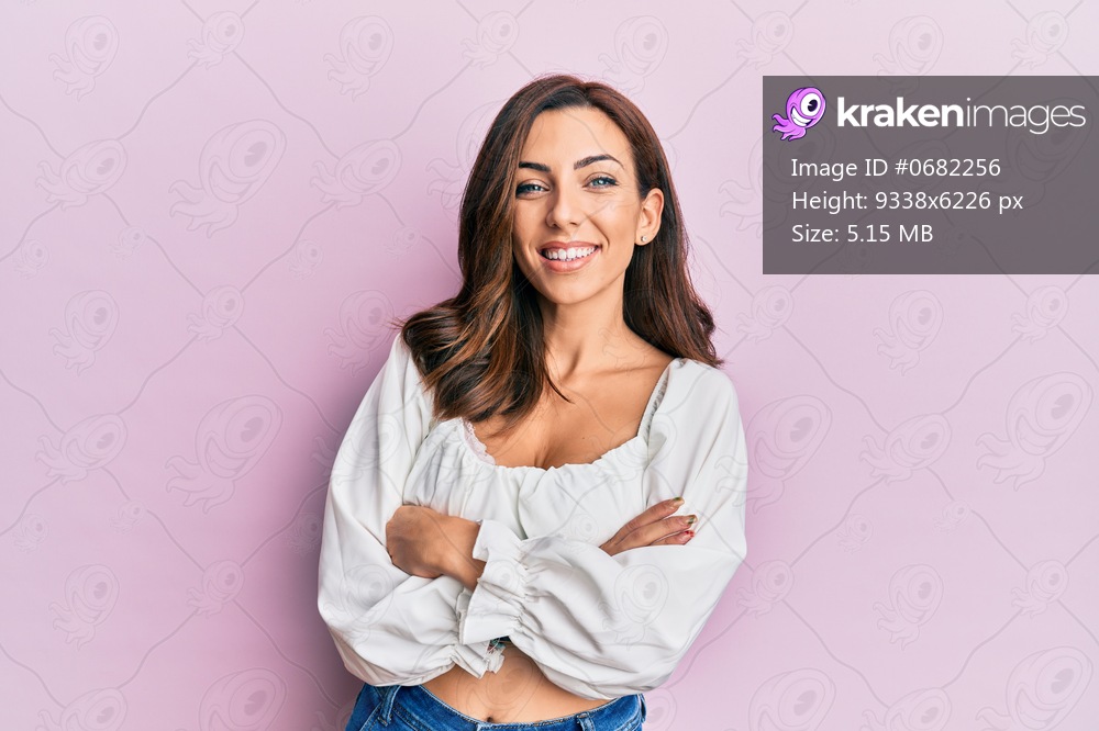 Young brunette woman wearing casual clothes over pink happy face smiling with crossed arms looking at the camera. positive person. 