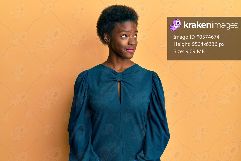 Young african american girl wearing casual clothes smiling looking to the side and staring away thinking. 