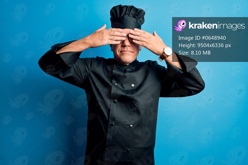 Middle age handsome grey-haired chef man wearing cooker uniform and hat covering eyes with hands smiling cheerful and funny. Blind concept.