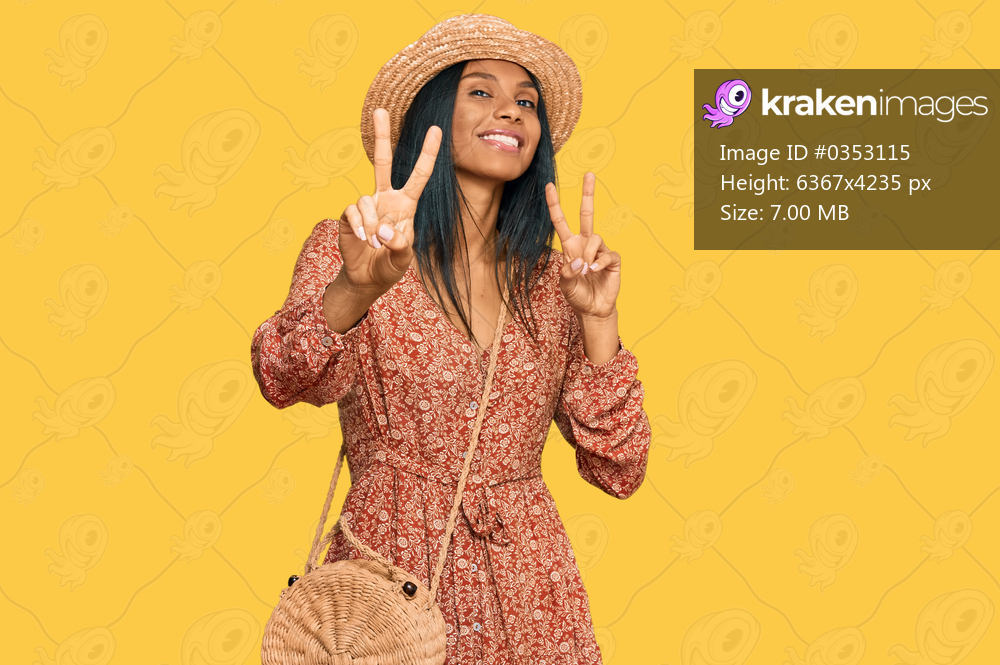 Young african american woman wearing summer hat smiling looking to the camera showing fingers doing victory sign. number two. 